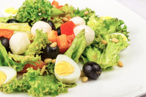 salad with quail eggs, pepper, olives, tomatoes and sesame seeds